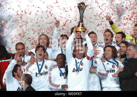 Paolo Maldini (C), of AC Milan, holds the champion trophy after