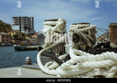 Mooring bollard, intertwined with mooring rope at the port in the Bay Stock Photo