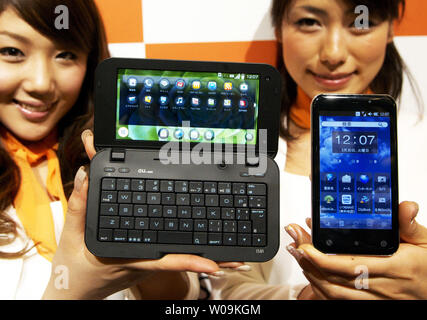 Models hold a smart phone IS01 (L), made by SHARP Corporation and IS02 (R), made by Toshiba Corporation, during a press conference in Tokyo, Japan, on March 30, 2010. "IS01" runs on the Google's Android operating system while the "IS02" has Microsoft's Windows mobile.     UPI/Keizo Mori Stock Photo