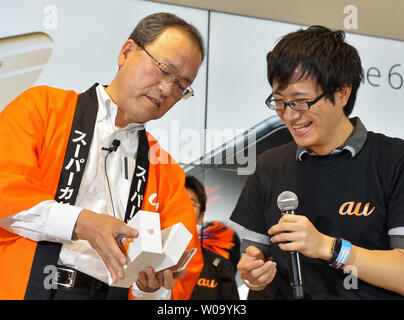 Koji Tanaka, President of KDDI Corporation speaks with first customer during launch day of new iPhone 6s and iPhone 6s Plus at the KDDI's au Shinjuku store in Tokyo, Japan, on September 25, 2015.     Photo by Keizo Mori/UPI Stock Photo