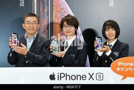 (L-R)Makoto Takahashi, President of KDDI Corporation, Japanese actors Ryunosuke Kamiki and Honoka Matsumoto pose for camera during a launch event for Apple New iPhone Xs and Xs Max at the KDDI's au Shinjuku store in Tokyo, Japan, on September 21, 2018.     Photo by Keizo Mori/UPI Stock Photo