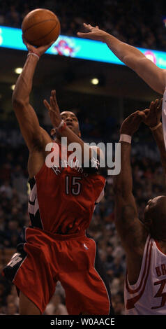 Toronto Raptors' Vince Carter takes a shot at the basket as Houston Rockets' Torraye Braggs tries to block in first quarter action at the Air Canada Center in Toronto, Canada on Nov. 16, 2003.  The Raptors remain unbeaten at home as they defeated the Rockets 101-97. (UPI Photo/Christine Chew) Stock Photo