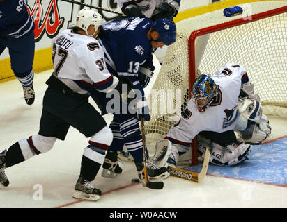Toronto Maple Leafs captain Mats Sundin tries to get control of the puck as he is challenged by Vancouver Canucks' Jarkko Ruutu and goalie Johan Hedberg in first period action at the Air Canada Center in Toronto, Canada on Nov. 24, 2003. (UPI Photo/Christine Chew) Stock Photo