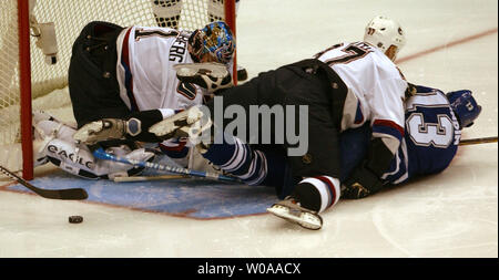 Vancouver Canucks' Jarkko Ruutu tackles Toronto Maple Leafs captain Mats Sundin onto the ice as Canucks goalie Johan Hedberg loses sight of the puck in first period action at the Air Canada Center in Toronto, Canada on Nov. 24, 2003. (UPI Photo/Christine Chew) Stock Photo