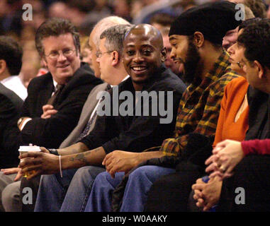 Actor Omar Epps(with drink in hand) chats with a friend at courtside during a timeout in the second quarter of the Toronto Raptors-Orlando Magic NBA game at the Air Canada Center in Toronto, Canada on Feb. 4, 2004. The Raptors defeated the Magic 110-90.  (UPI Photo/Christine Chew) Stock Photo