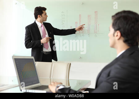 Businessman giving a presentation in board room Stock Photo