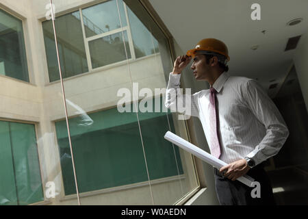 Indian male architect holding a blueprint Stock Photo