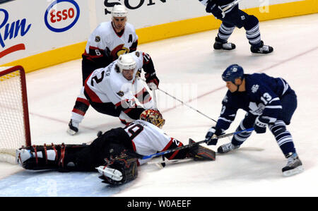 Toronto Maple Leafs captain Mats Sundin of Sweden flips the puck over Ottawa Senators goalie Martin Gerber as Mike Fisher and Wade Redden(no. 6) cover the play during first period action at the Air Canada Center in Toronto, Canada on October 24, 2006. The Senators defeated the Leafs 6-2. (UPI Photo/Christine Chew) Stock Photo