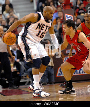 New Jersey Nets' Vince Carter tries to dribble the ball around Toronto Raptors' Jose Calderon of Spain during second quarter action at the Air Canada Center in Toronto, Canada on February 14, 2007. The Raptors defeated the Nets 120-109. (UPI Photo/Christine Chew) Stock Photo