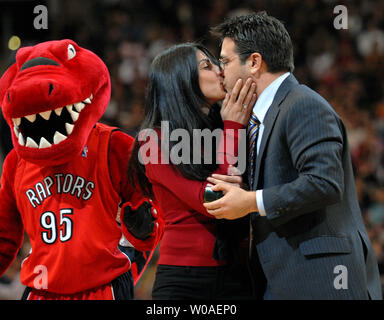 The Raptor mascot walks by to congratulate a couple as they kiss after getting engaged on court during a timeout in the second quarter as the Toronto Raptors host the New Jersey Nets in the Valentine's Day game at the Air Canada Center in Toronto, Canada on February 14, 2007. The Raptors defeated the Nets 120-109. (UPI Photo/Christine Chew) Stock Photo