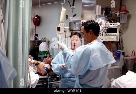 NAV2003033111 - USNS Comfort, Arabian Gulf, March 24 (UPI) -- Medical personnel work diligently on a wounded U.S. Marine inside the Casualty Receiving Area (CASREC) aboard the Military Sealift Command hospital ship USNS Comfort (T-AH 20) on March 24, 2003.           nn/U.S. Navy/Kevin H. Tierney       UPI Stock Photo