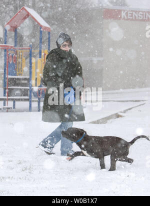 Local resident Robin Stewart walks her dog Jackie through Kensington Park in East Vancouver in snow which started falling early Thursday morning, January 6, 2005.    (UPI Photo/Heinz Ruckemann) Stock Photo