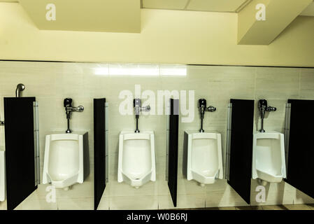 Four WC or urinal for men inside a building in New York City, USA Stock Photo