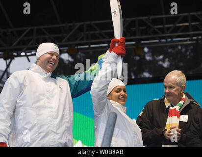 Caleb Taylor (L), 35 and Patricia Moreno, 18, dressed in Torchbearer uniforms unveil the Olympic Torch in Whistler Village, February 12, 2009, one year before the start of the Vancouver 2010 Winter Olympic Games in Vancouver, British Columbia. (UPI Photo/Heinz Ruckemann) Stock Photo