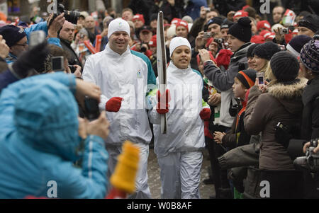 Caleb Taylor (L), 35 and Patricia Moreno, 18, dressed in Torchbearer uniforms unveil the Olympic Torch in Whistler Village, February 12, 2009, one year before the start of the Vancouver 2010 Winter Olympic Games in Vancouver, British Columbia. (UPI Photo/Heinz Ruckemann) Stock Photo