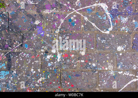 Colorful Paint Splattered and Dripped on old Bricks and Mortar surface Stock Photo