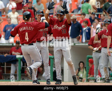 The Houston Astros pinch hitter Eric Bruntlett (4) is congratulated at home plate by Adam Everett (28) and Jose Vizcaino (10) following his three run home run to give the Astros a 4-1 lead in the 14th inning against Washington Nationals pitcher Hector Carrasco on July 24, 2005.  The Astros defeated the Nationals 4-1 at RFK Stadium in Washington, D.C. (UPI Photo/Mark Goldman) Stock Photo