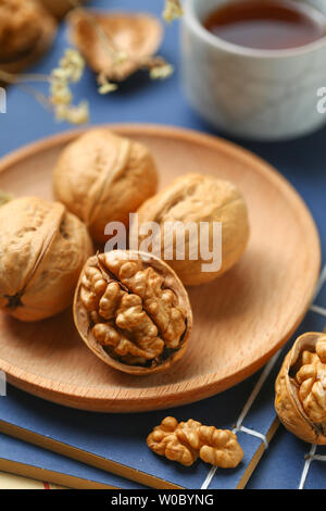 Peel off the cardboard walnuts and put them in a wooden tray. Stock Photo