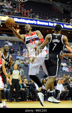 Washington Wizards center Nene Hilario (42) scores and is fouled by Brooklyn Nets shooting guard Joe Johnson (7) in the first half at the Verizon Center in Washington, D.C. on October 08, 2013.   UPI/Mark Goldman Stock Photo