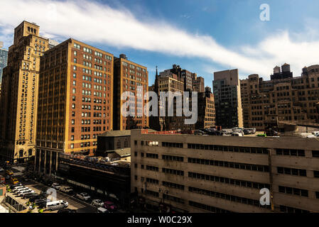 New York City, USA - July 31, 2018: Elevated view of a street with its skyscrapers, parking lot, traffic and people around in Manhattan, New York City Stock Photo