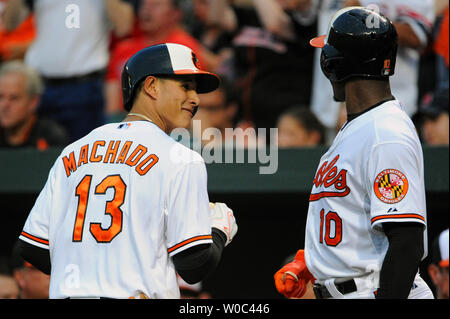 Baltimore Orioles' Adam Jones (L) and Manny Machado score against the Texas  Rangers on a double by Jonathan Schoop during the first inning at Camden  Yards in Baltimore, July 18, 2017. Photo