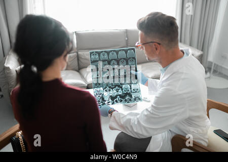 Plastic surgeon showing his client ultrasound investigation Stock Photo