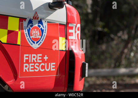 The cab door and emblem of the New South Wales Fire and Rescue Service on a truck parked in a suburban street during a Hazard Reduction burn in Sydney Stock Photo