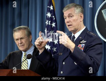 Chairman of the Joint Chiefs Richard Myers, right, anwers a question while Secretary of Defense Donald Rumsfeld, left, looks on, during a news conference at the Pentagon on January 6, 2004.  This was the first press conference of the year and both discussed their optimism for positive changes in Afghanistan and Iraq.   (UPI Photo/Michael Kleinfeld) Stock Photo