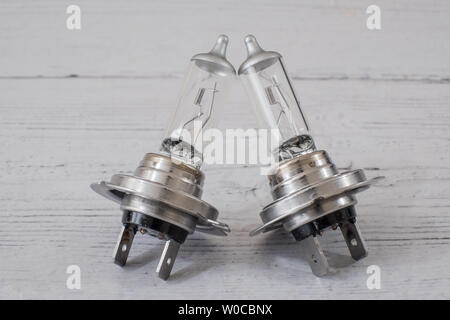 Two motor vehicle automotive halogen car light bulbs or lamps. Angled on a white painted board. Stock Photo