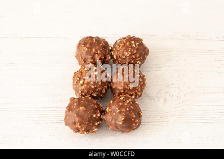 Six Nutty chocolate ice cream balls served on a white wooden painted board Stock Photo