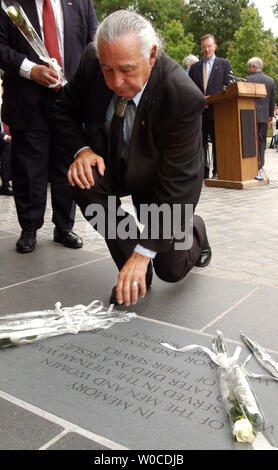 Sen. Ben Nighthorse Campbell, R-CO, lays a rose on the newly unveiled Vietnam Veterans Memorial Plaque on July 8, 2004, on the Mall in Washington. The plaque reads 'In memory of the men and women who served in teh Vietnam war and later died as a result of their service. We honor and remember their sacrifice.' Stock Photo