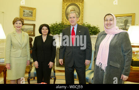 President George W. Bush welcomes Narmin Othman from Iraq and Dr. Massouda Jalal from Afghanistan, right, on March 9, 2005 to the Oval Office of the White House in Washington.  Both women are working for democracy in their respective countries.  First Lady Laura Bush looks on. (UPI Photo/Michael Kleinfeld) Stock Photo
