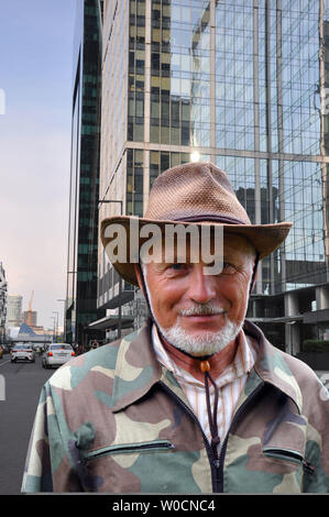 Middle aged traveler. Portrait of a handsome adult man with a gray beard and hat in camouflage clothes Stock Photo