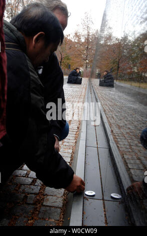 Members of Veterans For Peace and Veterans of the Vietnam War leave a keepsake at the Vietnam Veterans Memorial, during a campaign event bringing together victims of Agent Orange exposure, a deforestation chemical used in the Vietnam War, in Washington on November 28, 2005. Agent Orange has allegedly affected over 3 million people world wide, causing caner, birth defects, mental illness and other afflictions. This was part of a 10 city tour to bring awareness to those allegedly affected by the chemical. (UPI Photo/Kevin Dietsch) Stock Photo