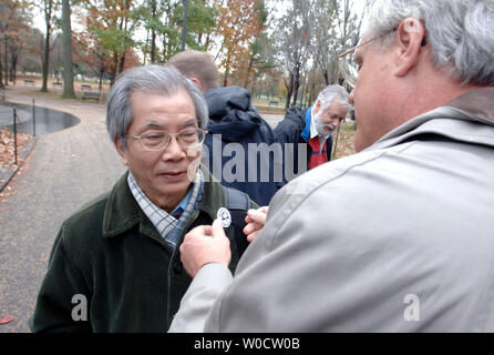 Former President of the Vietnam Red Cross Dr. Nguyen Trong Nhan (L) is given a Veterans For Peace button by Douglas Nelson of Veterans For Peace, at a campaign event bringing together victims of Agent Orange exposure, a deforestation chemical used in the Vietnam War, at the Vietnam Veterans Memorial in Washington on November 28, 2005. Agent Orange has allegedly affected over 3 million people world wide, causing caner, birth defects, mental illness and other afflictions. This was part of a 10 city tour to bring awareness to those allegedly affected by the chemical. (UPI Photo/Kevin Dietsch) Stock Photo