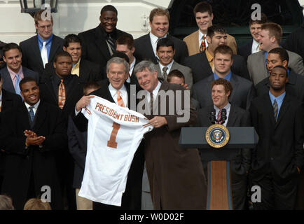 U.S. President George W. Bush receives a jersey from Head Coach Mack Brown as Bush hosts the University of Texas Long Horns national championship football team on the South Lawn of the White House on February 14, 2006.     (UPI Photo/Roger L. Wollenberg) Stock Photo