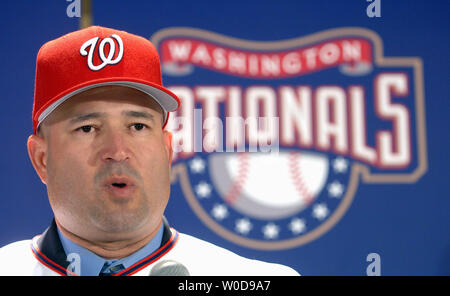 Manny Acta dons his jersey and hat after he was announced as the