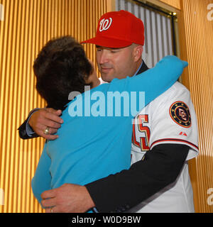 Manny Acta dons his jersey and hat after he was announced as the