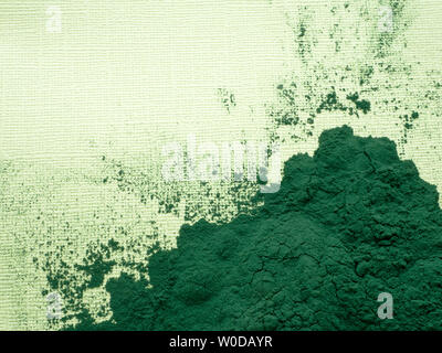 Spirulina algae tablets and powder on green background from top view Stock Photo