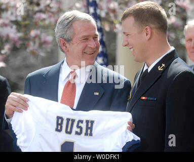 U.S. President George W. Bush holds up a jersey given to him by Naval Academy football co-captain Rob Caldwell (R) during the presentation of the Commander-in-Chief trophy to the United States Naval Academy football team, at a ceremony at the The White House in Washington on April 2, 2007. The Commander-in-Chief's Trophy is awarded each season to the winner of the triangular college football series among the United States Military Academy, the United States Naval Academy and United States Air Force Academy. (UPI Photo/Kevin Dietsch) Stock Photo