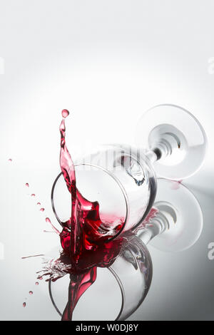 Red wine spilled out of a falling glass reflected on the surface Stock Photo