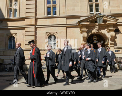 Celebration day at the university of Cambridge, England, as graduand students (from Trinity Hall college) in their academic gowns process in an orderly queue from their college to enter Senate House on 27th June 2019 for their graduation ceremony. Stock Photo