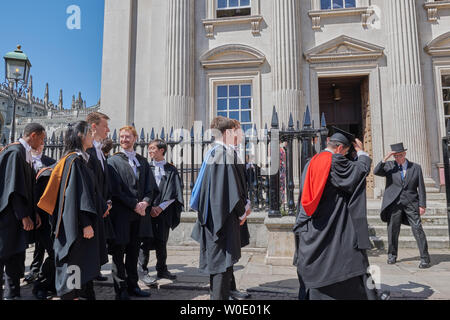 Celebration day at the university of Cambridge, England, as graduand students (from Trinity Hall college) in their academic gowns line up in an orderly queue to enter Senate House on 27th June 2019 for their graduation ceremony. Stock Photo