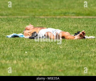 London. 27th June 2019. UK Weather: Sunshine in Green Park, London Man in shorts sunbathing on grass Credit: Ian Davidson/Alamy Live News Stock Photo