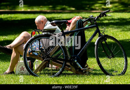 London. 27th June 2019. UK Weather: Sunshine in Green Park, London Credit: Couple on deckchairs with bike Ian Davidson/Alamy Live News Stock Photo