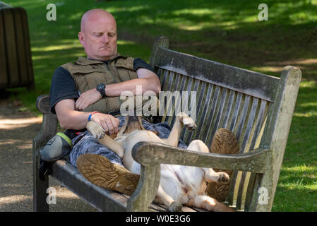 London. 27th June 2019. UK Weather: Sunshine in Green Park, London Man with dog on bench  Credit  Ian Davidson/Alamy Live News Stock Photo