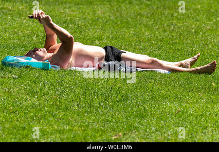 London. 27th June 2019. UK Weather: Sunshine in Green Park, London Man sunbathing  Credit: Ian Davidson/Alamy Live News Stock Photo