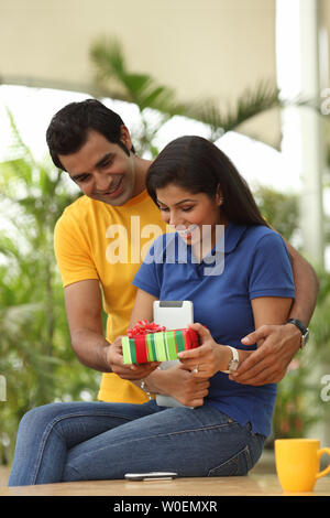 Indian young man giving a gift to a woman Stock Photo