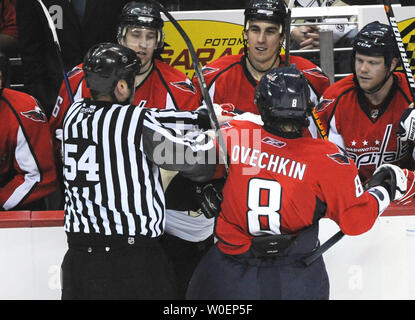 NHL stars Pittsburgh Penguins Sidney Crosby (87) and Washington Capitals Alexander Ovechkin (8) are separated by linesman Greg Devorski (54) after Crosby checked Ovechkin into the boards in front of the Washington bench in the second period during game at the Verizon Center in Washington, DC on February 22, 2009.   (UPI Photo/Pat Benic) Stock Photo