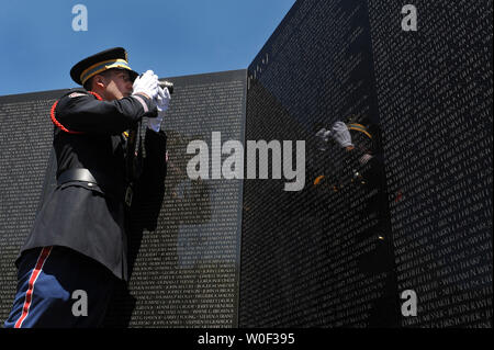 Wentworth Military Academy Cadet Capt. Joel Fowler, 18, takes a photograph of the first two names on the Vietnam Veterans Memorial during a ceremony honoring the 50th anniversary of the first two American combat casualties of the Vietnam War, in Washington on July 8, 2009. The ceremony honored Army Master Sgt. Chester Ovnand and Maj. Dale Buris who died on July 8, 1959 when their compound was attached by North Vietnamese communist. (UPI Photo/Kevin Dietsch)   . Stock Photo